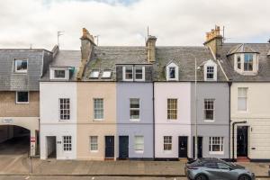 a row of white houses with a car parked in front at 114 North Street in St. Andrews