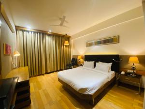 a bedroom with a large white bed in a room at The Manak Bagh in Sehore