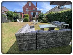 a backyard with a couch and a table in the grass at Britmead Guesthouse in West Bay