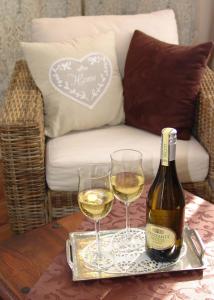 a bottle of wine and two glasses on a table at Hotel Garni Landhaus Uttum in Greetsiel