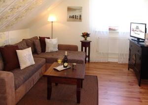 a living room with a couch and a table at Hotel Garni Landhaus Uttum in Greetsiel
