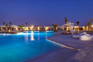 a pool at a resort at night at The Waterfront Cabins at D-Bay - Lemon Spaces in Zāwiyat ‘Abd al Mun‘im