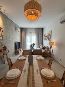 a living room with a large wooden table with plates on it at The Waterfront Cabins at D-Bay - Lemon Spaces in Zāwiyat ‘Abd al Mun‘im +32 photos