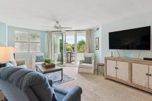 a living room with a couch and a flat screen tv at North Breakers 201 in Saint Simons Island