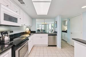 a kitchen with white cabinets and black appliances at North Breakers 201 in Saint Simons Island