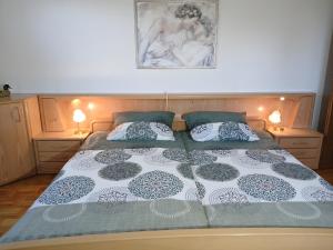 a bed with two pillows and a picture on the wall at FeWo Waldblick in Salzhemmendorf