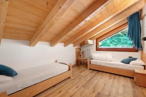 two beds in a room with a window at Maso Rubino in Rabbi