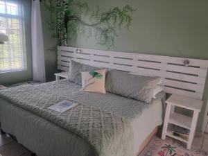 a bedroom with a large bed with a white headboard at Franmarel in Plettenberg Bay