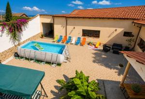 a patio with a pool and chairs and a house at Casa Adelin in Eşelniţa