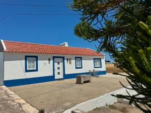 a blue and white building with a red roof at Casa Isqueiro in Cela