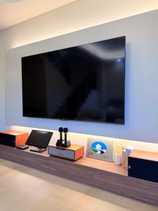 a large flat screen tv hanging on a wall at 想睡覺民宿 in Hsia-ch'ing
