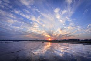 a sunset on a beach with the sun in the sky at KAMENOI HOTEL Itako in Itako