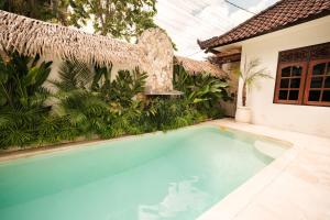 a swimming pool in front of a house at Santai Studios in Badung