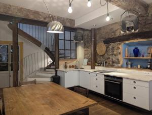 a kitchen with a wooden table and a staircase at The Artist's House in Céret