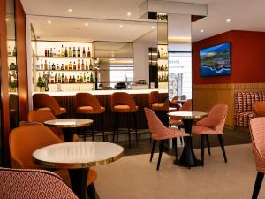 a restaurant with tables and chairs and a bar at Hôtel De Castiglione in Paris