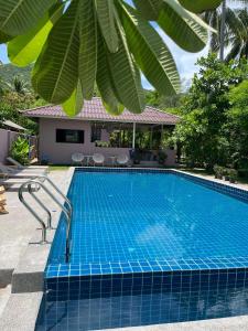 a swimming pool in front of a house at Boonya Swiss Home in Chaloklum