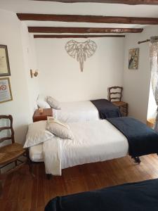 two beds in a room with white walls and wooden floors at Auberge de la Belette in Le Monestier +35 photos