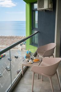 a balcony with two chairs and a table with food on it at Alezzi Beach Resort in Mamaia Sat/Năvodari