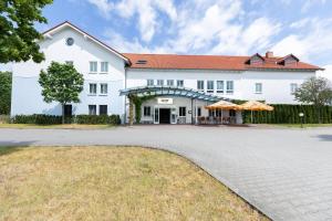 a large white building with a driveway at Garner Hotel Cottbus Süd by IHG in Cottbus