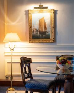a dining room with a table and a painting of a ship at Rosewood Jeddah in Jeddah