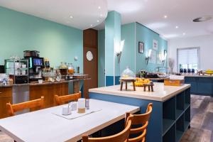 a restaurant with blue walls and a table and chairs at Garner Hotel Cottbus Süd by IHG in Cottbus