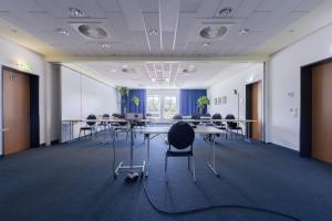 a conference room with tables and chairs in an office at Garner Hotel Cottbus Süd by IHG in Cottbus