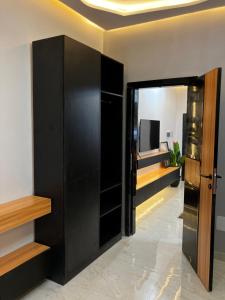 a room with black cabinets and a television at Le confort dans la simplicité in Lomé