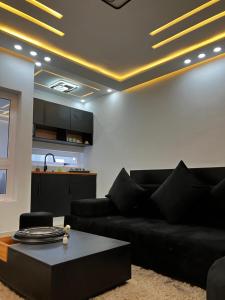 a living room with a black couch and a table at Le confort dans la simplicité in Lomé