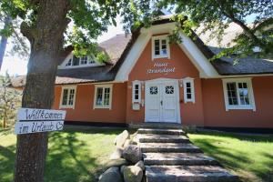 a small orange house with a sign in front of it at Haus Strandgut FW 5 in Ahrenshoop