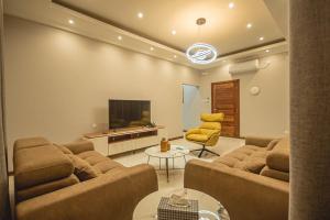 a living room with a couch and a flat screen tv at Ultra Aparthotel in Tete