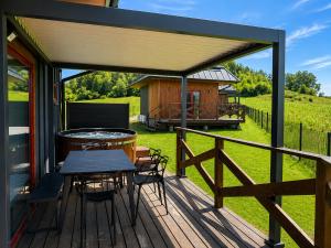a deck with a table and chairs and a cabin at D'Pazur- sauna, jacuzzi in Białka Tatrzańska