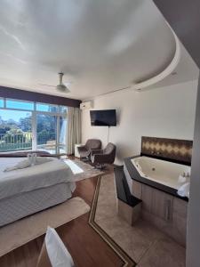 a bedroom with a bed and a tub and a tv at Estrela Palace Hotel in Estrêla +114 photos