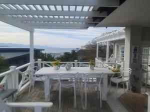 a white table and chairs on a deck with a view at Franmarel in Plettenberg Bay