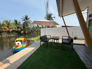 a patio with a table and chairs and an inflatable pool at My friend private pool villa in Samut Songkhram