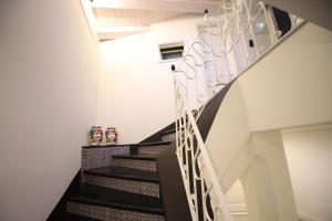 a staircase in a house with white walls and black stairs at Sinfonia Barocca in Modica +20 photos