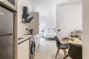 a kitchen and dining room with a table and chairs at Apartamentos Surya Home Suites in Conil de la Frontera