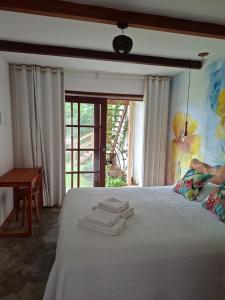 a bedroom with a bed with towels on it at Dona Maragô Pousada in Maragogi