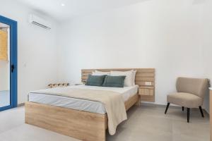 a bedroom with a bed and a chair at Khōra Suites Matala in Matala