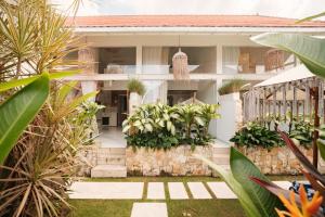 a white house with plants in front of it at Santai Studios in Badung
