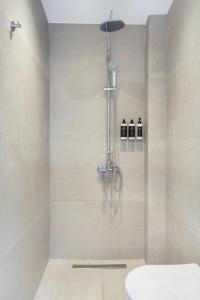 a bathroom with a shower with a toilet in it at Khōra Suites Matala in Matala +25 photos