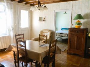 a dining room with a table and a bed at gite 618 in Helfaut