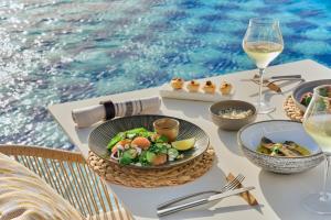 a table with a plate of food and a glass of wine at Amare Beach Hotel Sancti Petri - Adults Recommended in Chiclana de la Frontera +14 photos