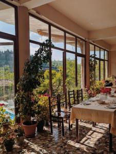 a dining room with a table and some plants at Mate Guesthouse in Sighnaghi