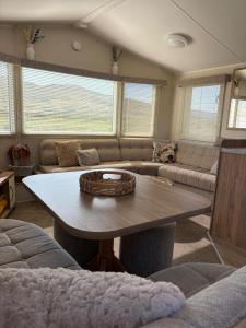 a living room with a table and a couch at Dotties Den at Sunnysands in Llanddwywe