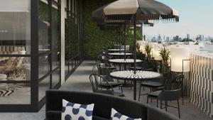 a patio with tables and chairs and a view of the city at Holiday Inn & Suites Tijuana Downtown by IHG in Tijuana