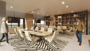 two people walking around a room with a table and chairs at Holiday Inn & Suites Tijuana Downtown by IHG in Tijuana