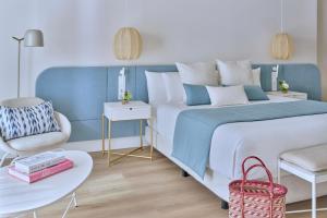 a blue and white bedroom with a bed and a chair at Amare Beach Hotel Sancti Petri - Adults Recommended in Chiclana de la Frontera