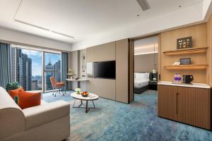 a living room with a couch and a room with a bed at Crowne Plaza Dalian Kerren in Dalian