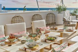 a table with food on a balcony with the ocean in the background at Amare Beach Hotel Sancti Petri - Adults Recommended in Chiclana de la Frontera