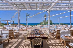 a restaurant with tables and chairs and the ocean at Amare Beach Hotel Sancti Petri - Adults Recommended in Chiclana de la Frontera